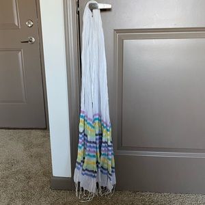 White scarf with light colored stripes on the ends